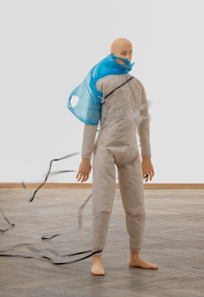 Mannequin with plastic hanging from it.