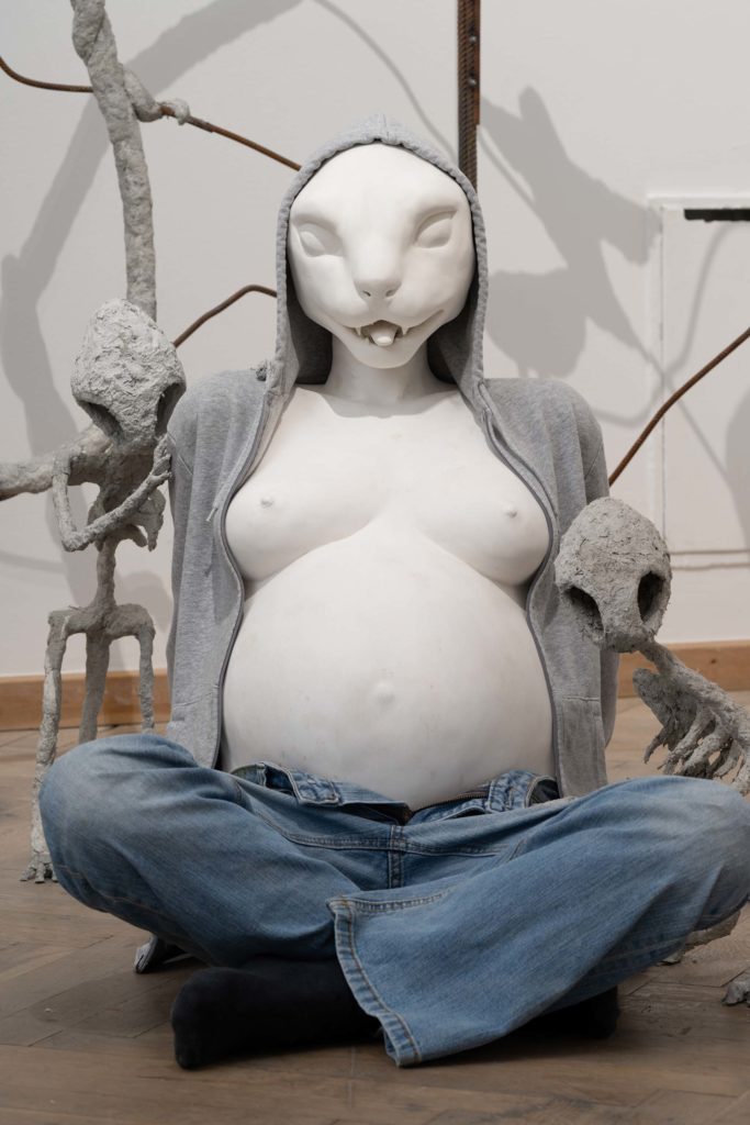 En skulptur af en gravid kvinde med dyreansigt.