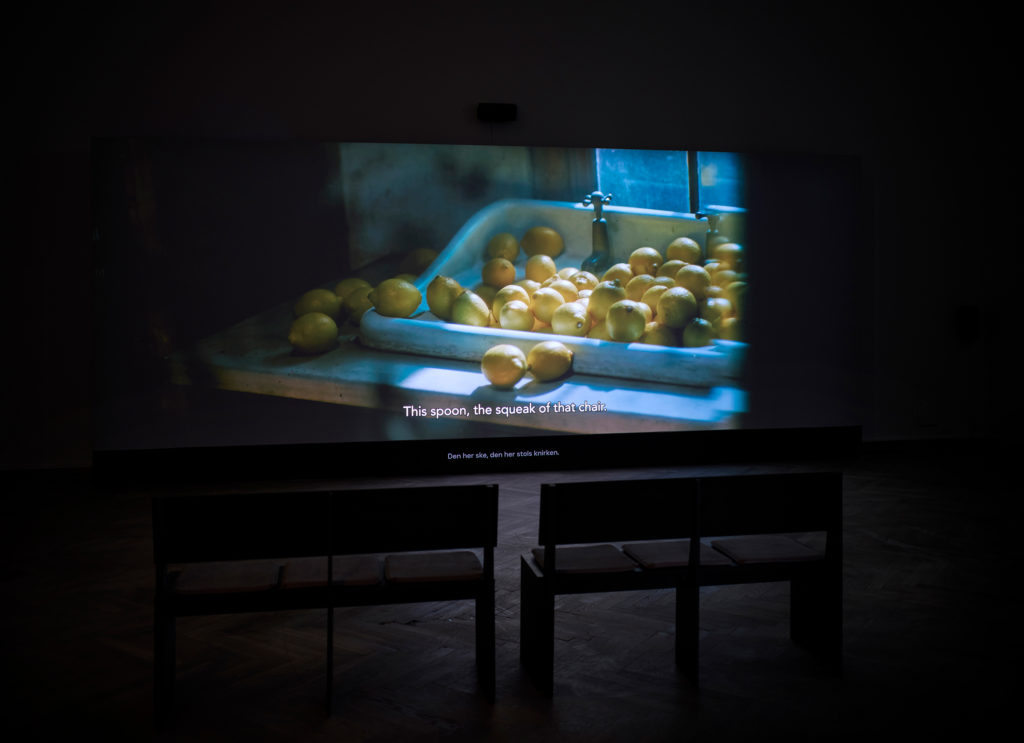 En film vises i et mørkt udstillingsrum.