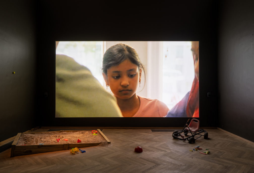 Et billede af en storskærm, i et mørkt udstillingsrum.