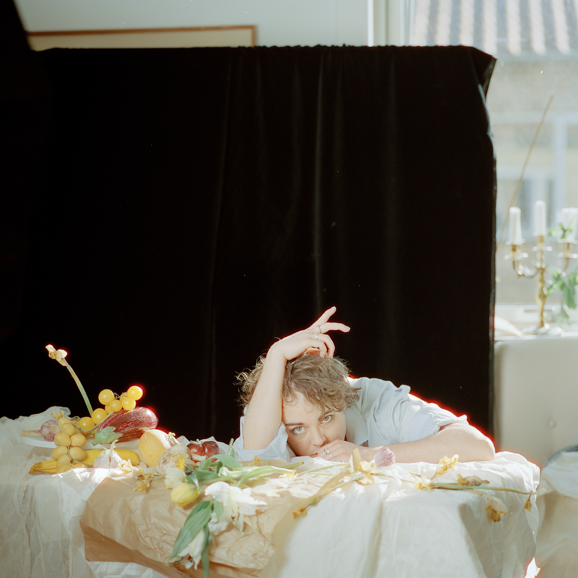 En person sidder ved et bord med frugt og grøntsager på