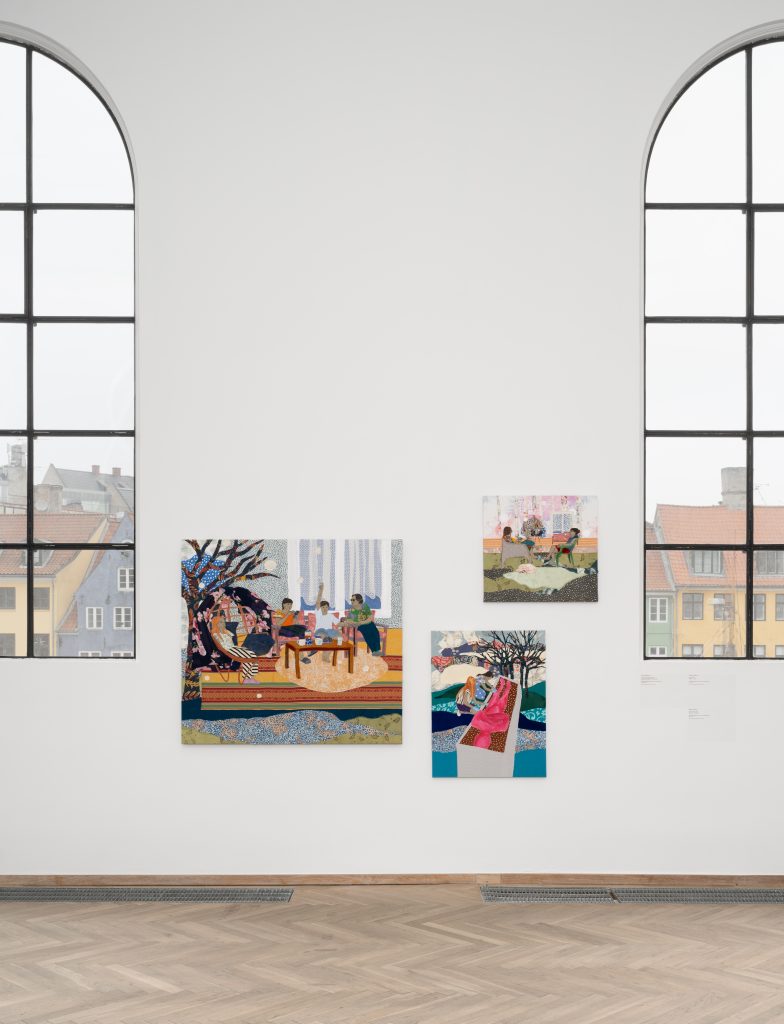 Three textile artworks in an exhibition space.