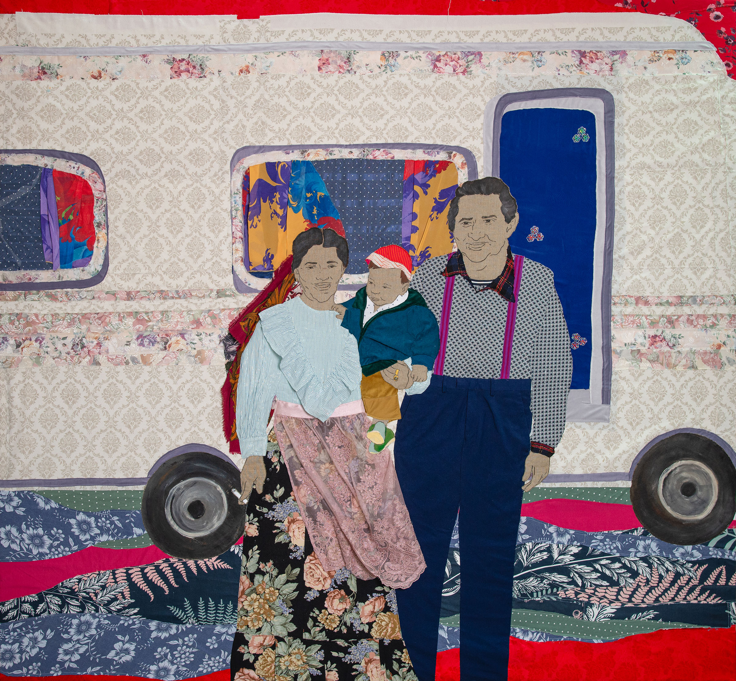Et kunstværk i tekstiler af to voksne og et barn.